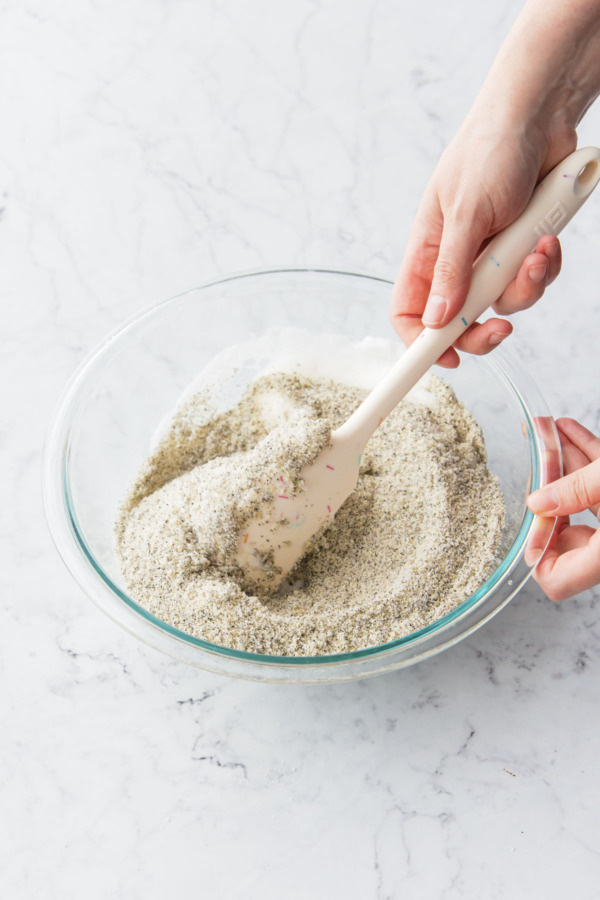 Mixing the dry ingredients into the whipped egg whites with a rubber spatula.